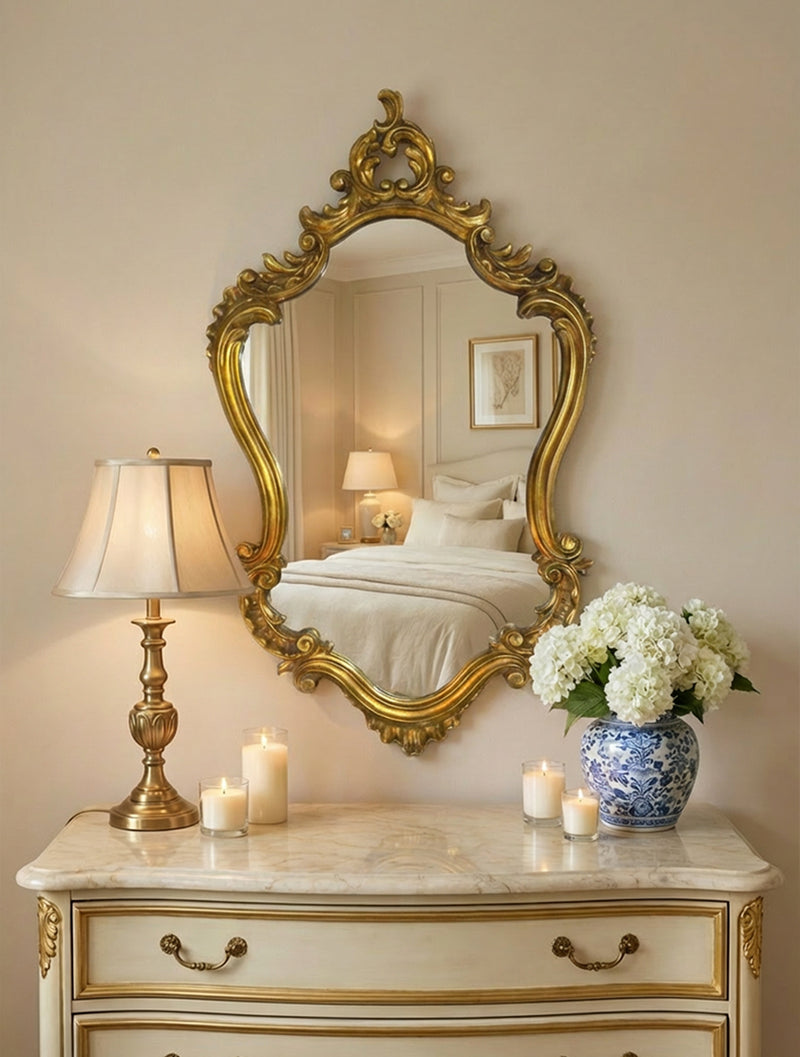 מראת קיר בארוק מוזהבת עם מסגרת מעוטרת צעל שידת מגירות שמנת בחדר שינה קלאסי