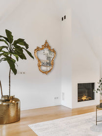 מראה בסגנון צרפתי מהמהאה ה 18 בסלון מינימליסטי עם אח דולקת