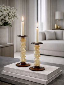 פמוטים ענבריים מדורגים Amber מזכוכית עם בסיס כהה על שולחן מעוצב