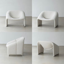 כורסה מעוצבת עם מבנה פיסולי וקווים מעוגלים לסלון מודרני