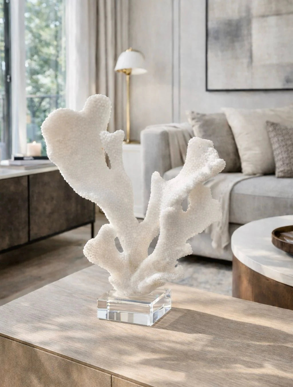 פסל אלמוג Coral Blanc בצבע בהיר עם בסיס קריסטל על מדף בעיצוב מודרני