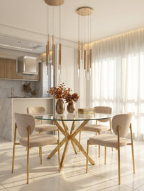 כיסא אוכל מרופד בגוון שמנת עם גב מעוגל ורגלי מתכת בגימור זהב, בתוך מטבח לבן בשעת בין ערביים