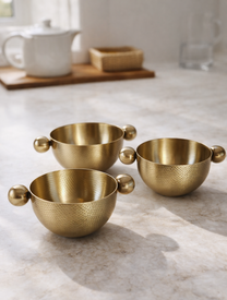 קערות לפיצוחים ולנשנושים מנירוסטה בגימור זהב על שיש במטבח