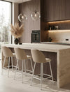 שלושה כיסאות בר LUNA בגוון בז'־אבן עם ריפוד בהיר ובסיס מתכת לבן מט סביב אי אבן במטבח מודרני עם ארונות עץ
