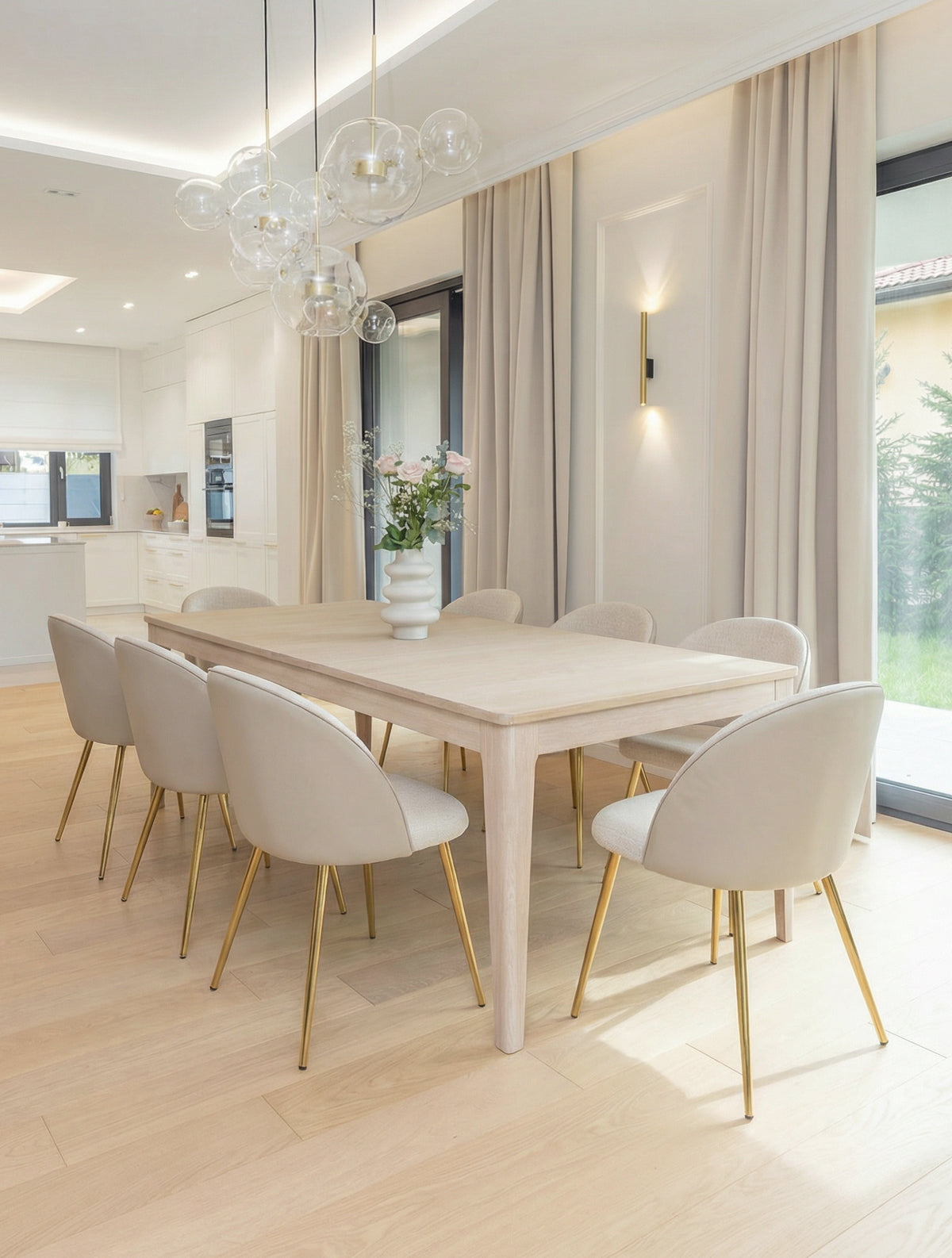 כיסאות אוכל LUNA בצבע אבן בהיר עם רגלי זהב סביב שולחן עץ בחלל מואר, כיסאות לפינת אוכל יוקרתיים לאירוח