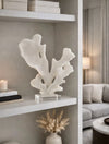 פסל אלמוג Coral Blanc בצבע בהיר עם בסיס קריסטל על מדף בעיצוב מודרני
